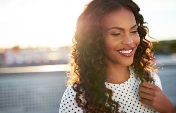 Smiling beautiful Afro-American woman with wavy long hair.
