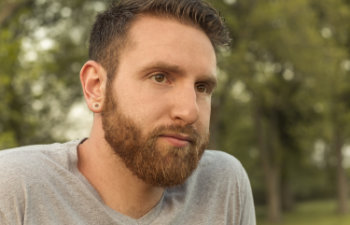 bearded young man with gauged ears and stylish haircut